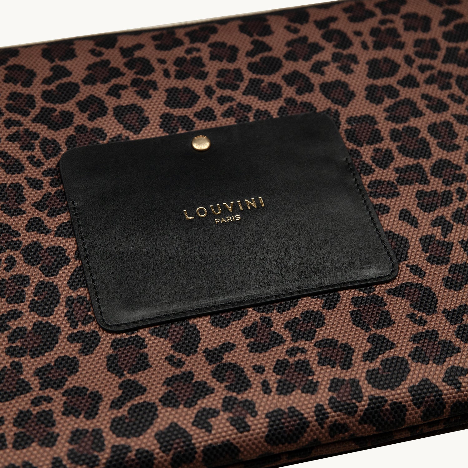 Pochette en tissu imprimé léopard avec détail en cuir noir, accessoire élégant et pratique