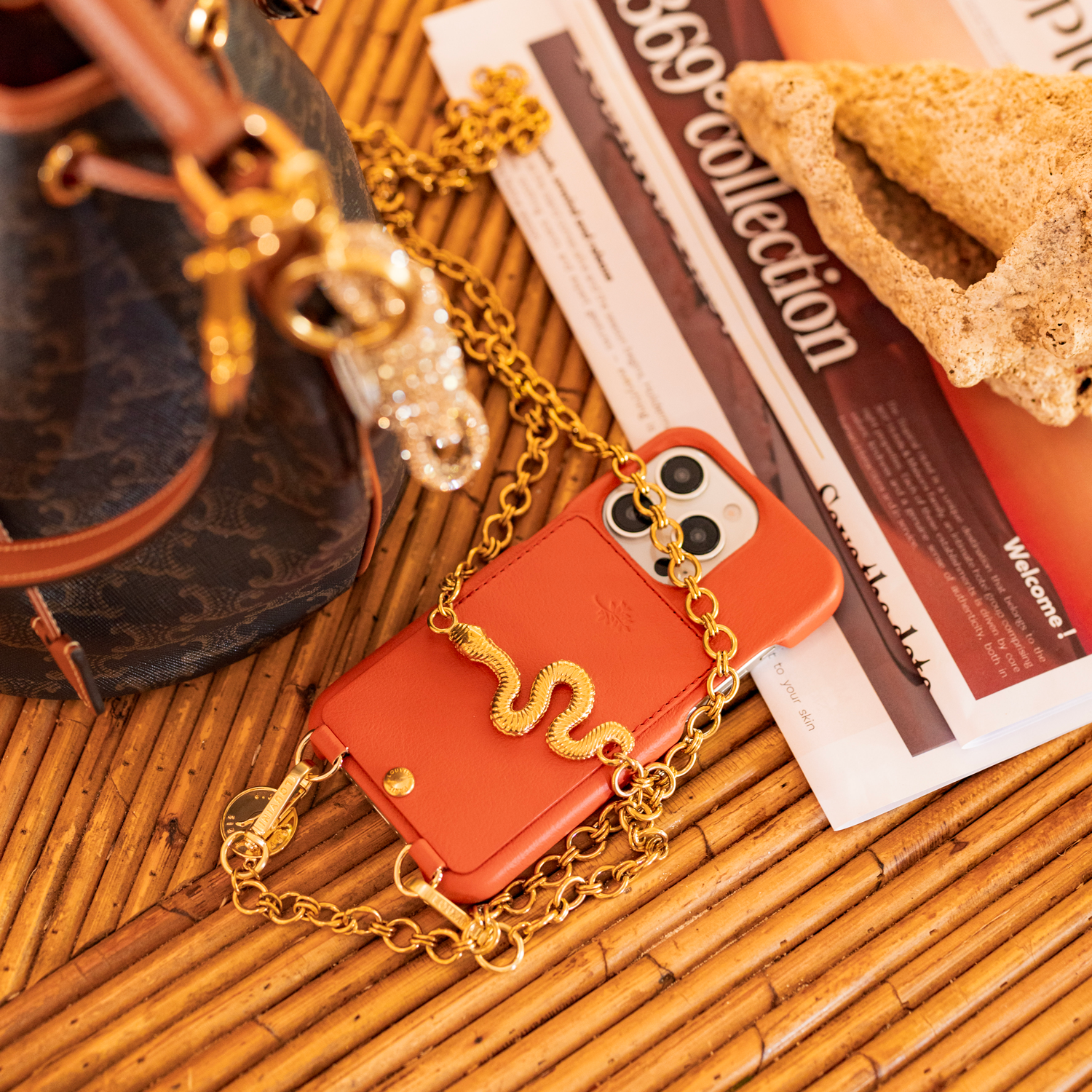 coque iphone en cuir orange louvini les airelles avec chaine bandoulière dorée serpent