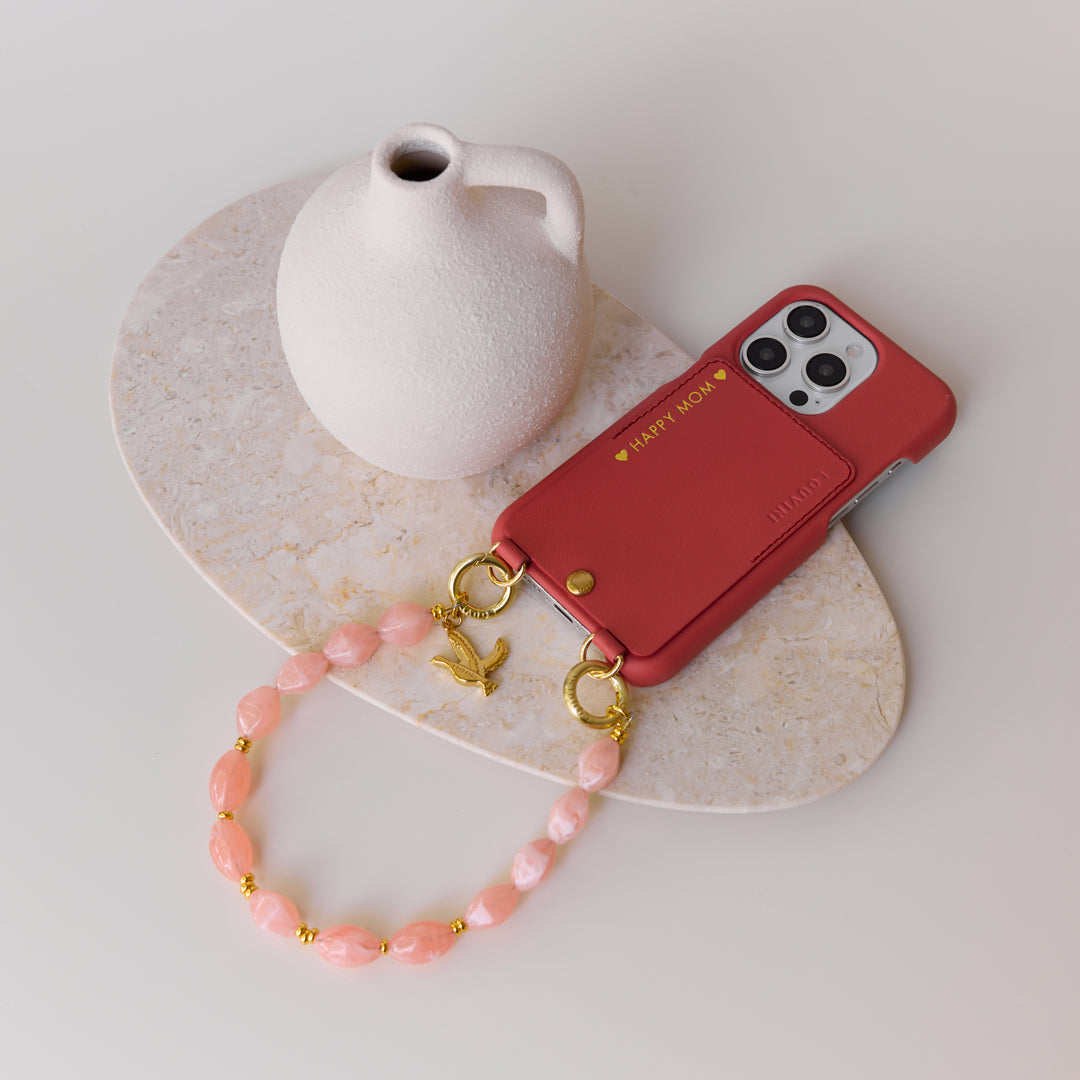 coque iphone rose blush en cuir avec personnalisation et bracelet de téléphone perles corail