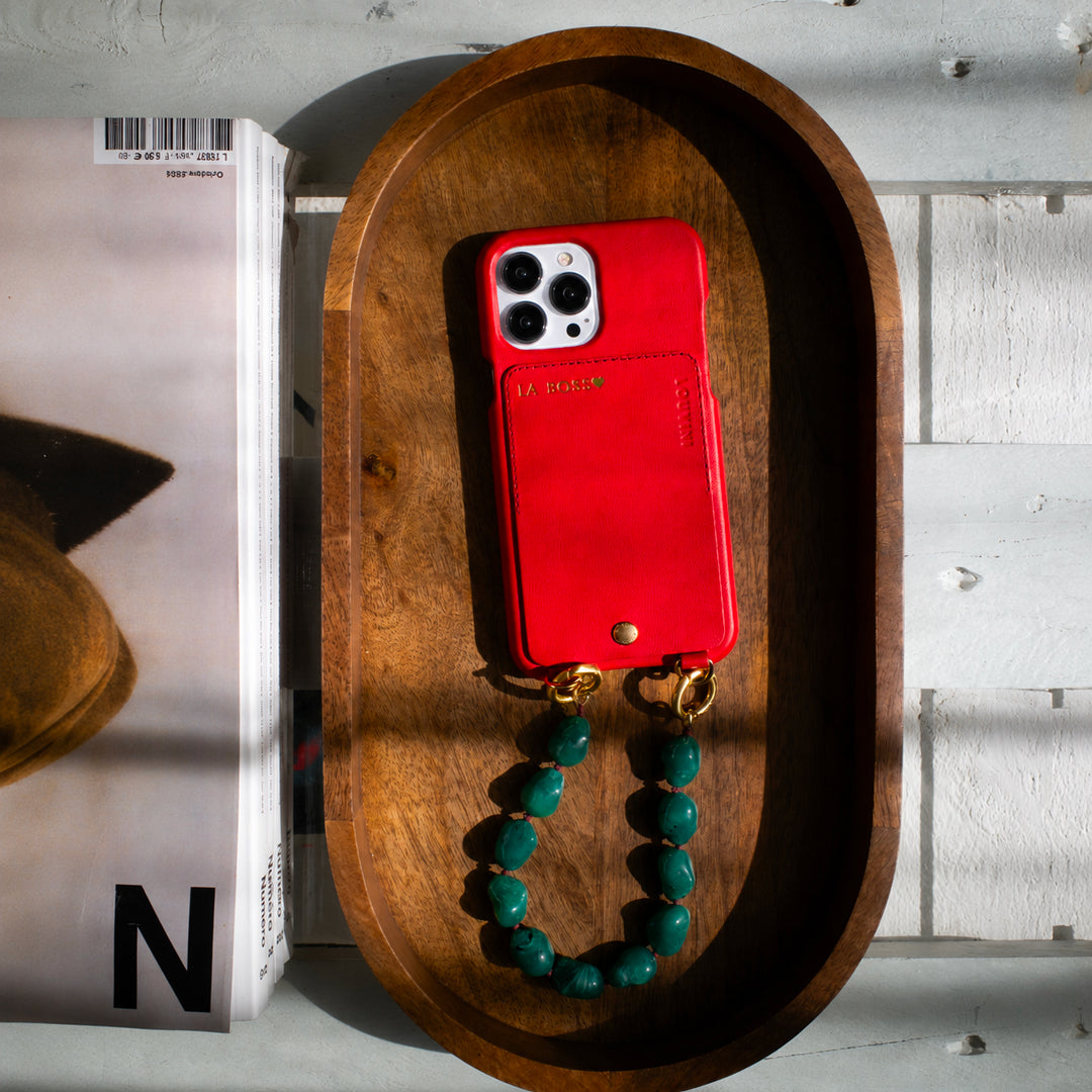 coque iphone en cuir personnalisable rouge avec bracelet de téléphone à perles vertes