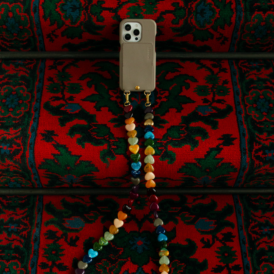 coque iphone beige taupe en cuir avec porte-carte intégré et bandoulière de téléphone à perles coeurs multicolores