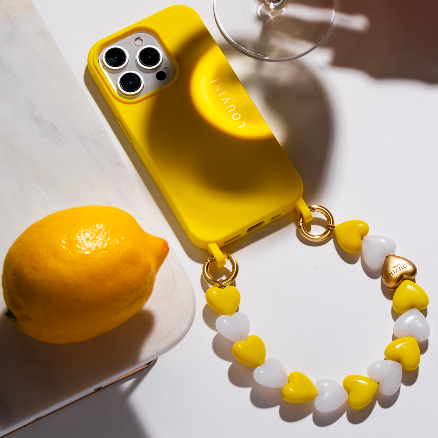 coque iphone jaune avec anneaux et bracelet à perles petits coeurs jaunes blancs