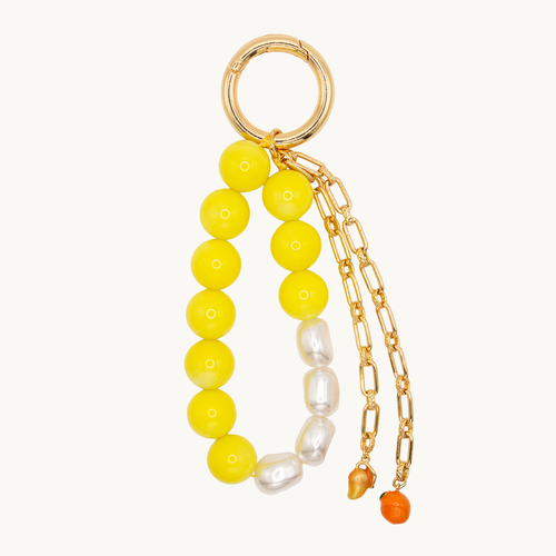 Grigri pour sac ou coque de téléphone en perles jaunes et blanches avec chaînes et charms, accessoire tendance