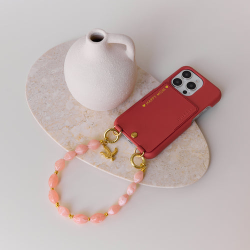 coque iphone rose blush en cuir avec personnalisation et bracelet de téléphone perles corail