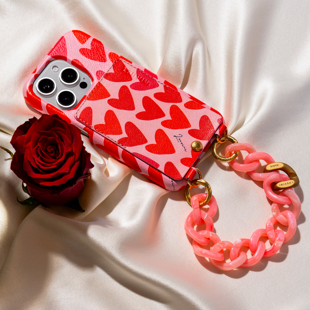 coque iphone en cuir imprimé coeurs rose rouge et bracelet de téléphone chaine à maillons rose