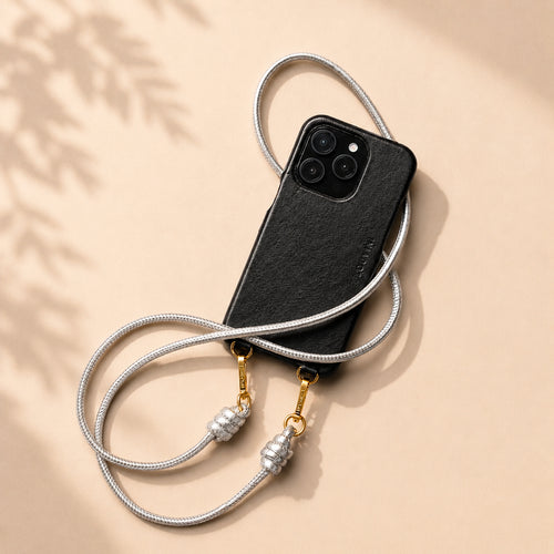 coque iphone en cuir noir avec magsafe intégré et cordon de téléphone en cuir argenté métallisé