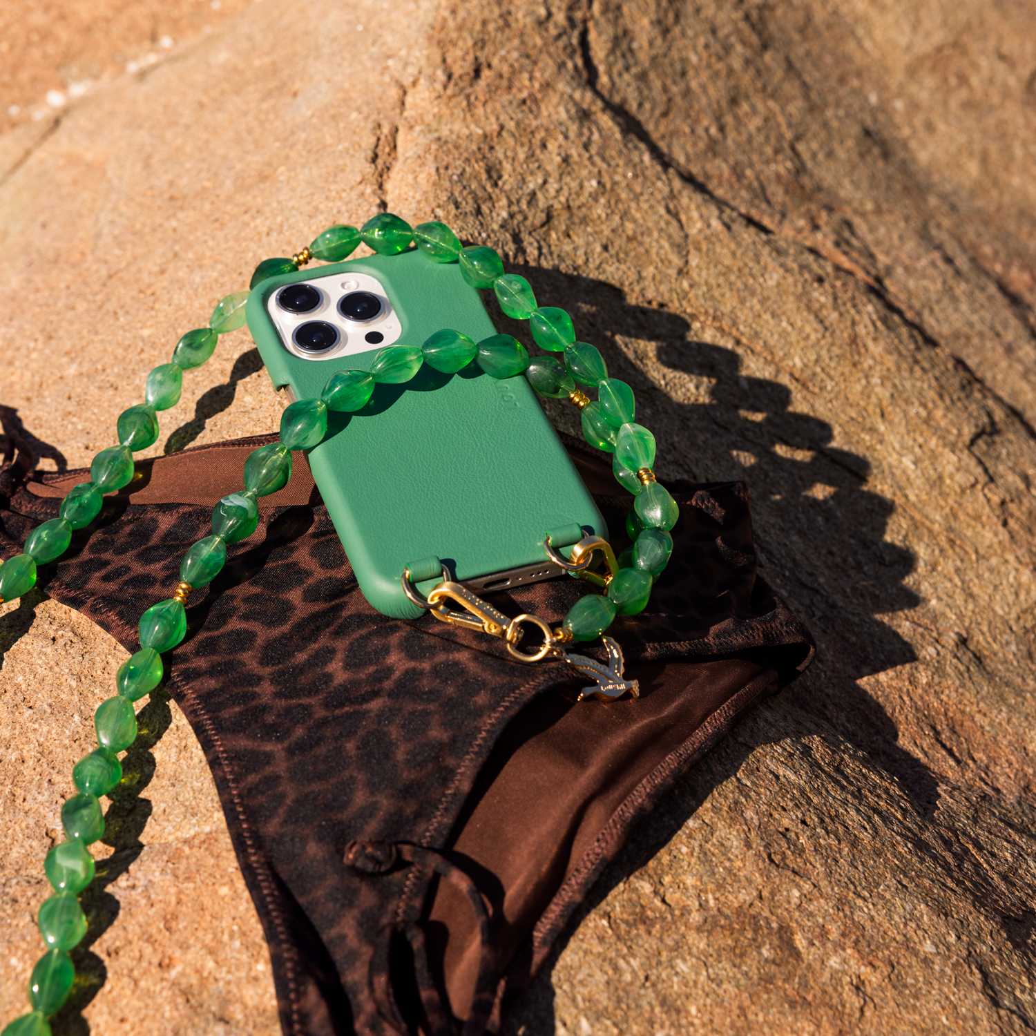 coque iphone en cuir vert émeraude magsafe intégré avec anneaux et chaine bandoulière de téléphone à perles vertes